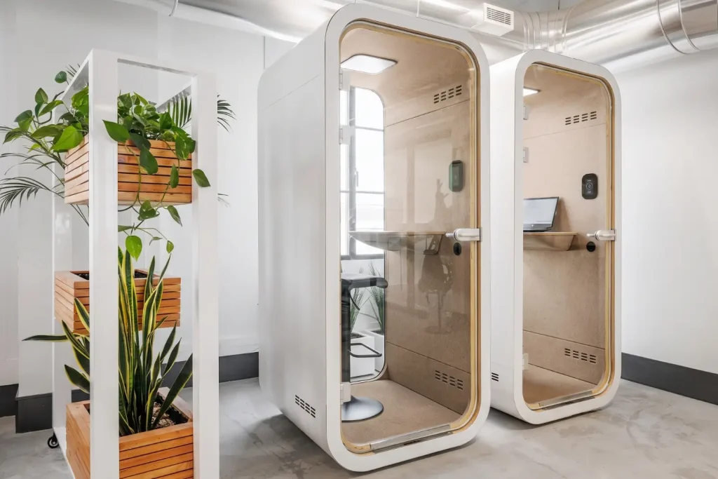 Dos cabinas privadas de trabajo MOOD Phone en una oficina moderna, junto a una jardinera vertical
