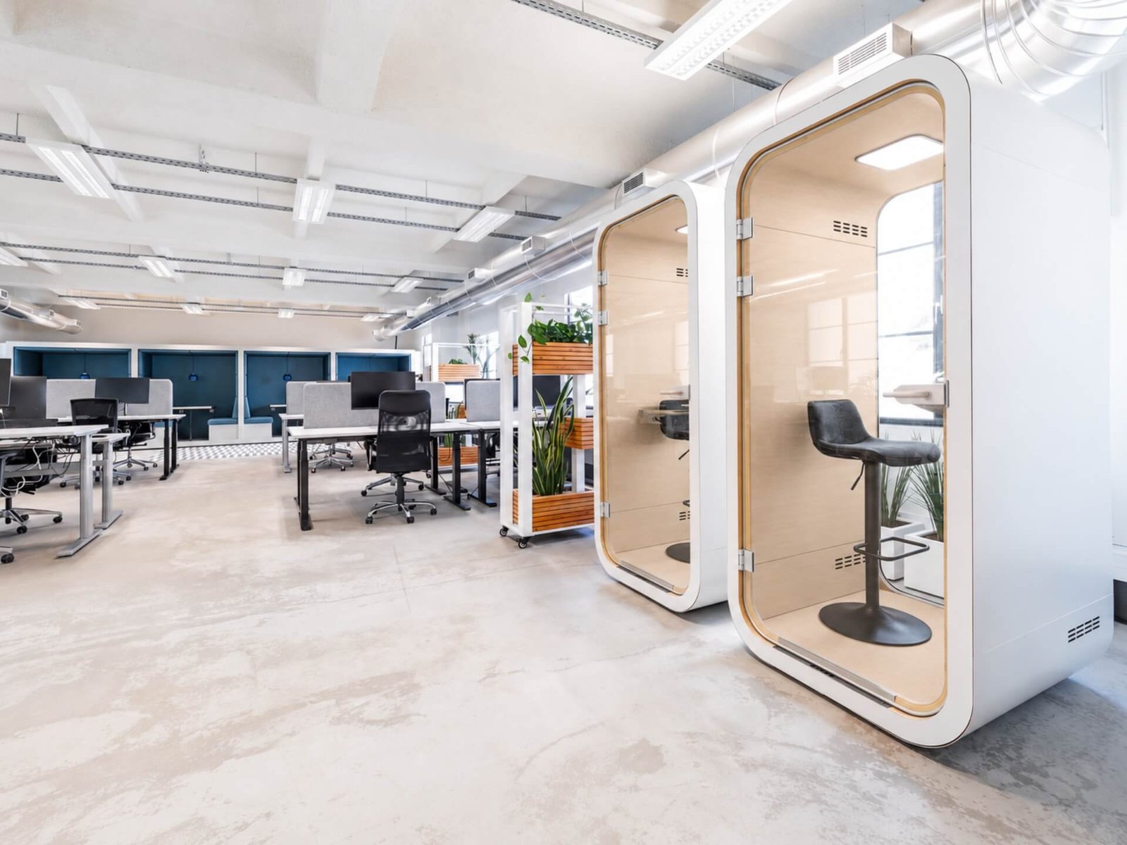 Oficina moderna con escritorios, sillas, plantas y cabinas privadas de trabajo MOOD Phone